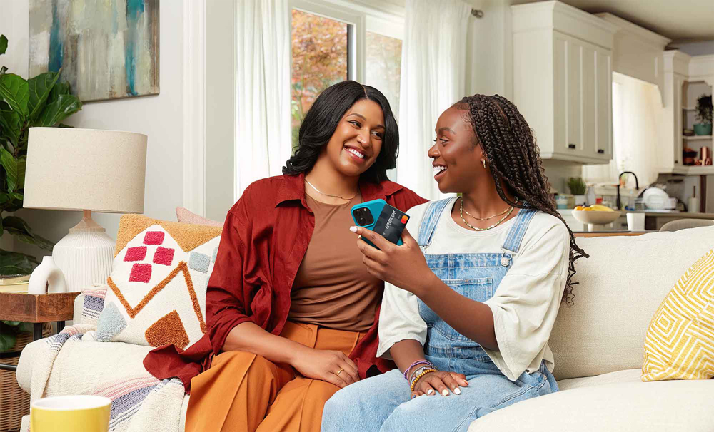 Two women talking looking at phone