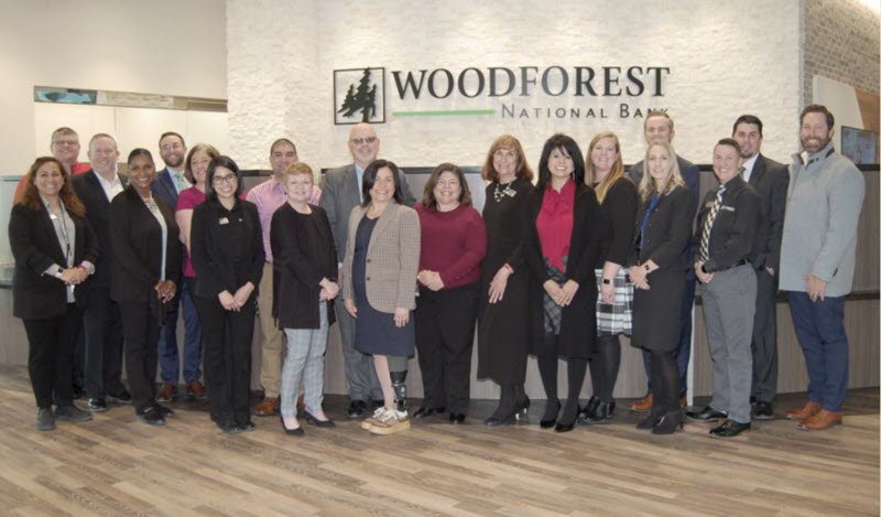 Bank employees gather with representatives from The City of Conroe and the Conroe - Lake Conroe Chamber of Commerce during the soft opening of the newly re-built Woodforest National Bank building in Downtown Conroe. (Photo by Liz Grimm)